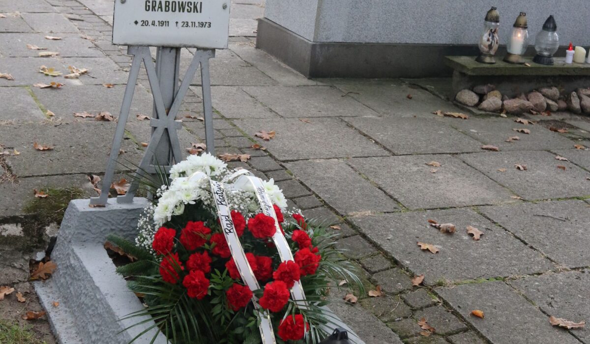 Grób ks. Aleksandra Grabowskiego na cmentarzu zakonnym w Niepokalanowie z biało-czerwoną wiązanką i zniczami