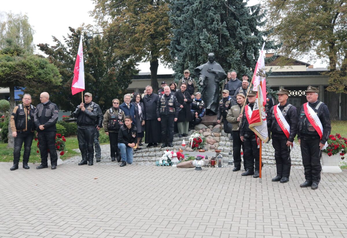 Uczestnicy Rajdu Katyńskiego z flagami i sztandarem pod pomnikiem św. Maksymiliana Kolbego w Niepokalanowie
