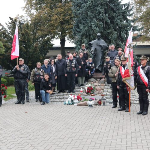 Uczestnicy Rajdu Katyńskiego z flagami i sztandarem pod pomnikiem św. Maksymiliana Kolbego w Niepokalanowie